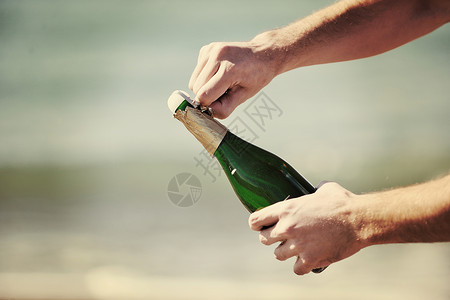 男子手打开瓶香槟酒葡萄酒饮料户外派庆祝活动背景图片
