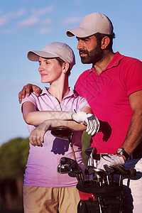 高尔夫球场上幸福轻夫妇的肖像高尔夫球场上夫妇的肖像图片