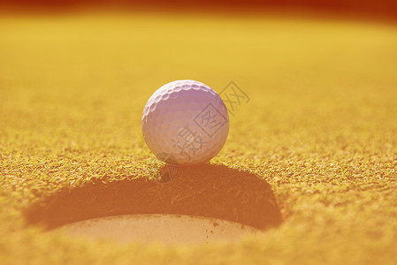 球场边缘的高尔夫球代表着成就成功的商业理念洞里的高尔夫球图片