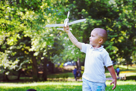 快乐的男孩公园玩扔飞机带空气的男孩图片