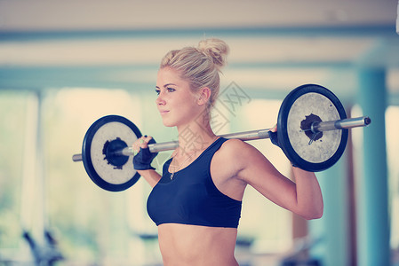 健康健康的轻女健身健身房举重锻炼她的臀部肌肉轻女子健身健身房举重图片