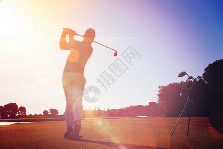 高尔夫球手击球与球杆美丽的早晨与太阳耀斑背景高尔夫球运动员用棍棒击球背景图片