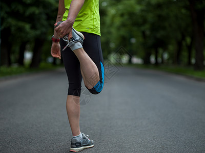 女跑步者早上训练前热身伸展健康的女跑步者早上训练前城市公园热身伸展图片