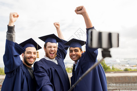 教育毕业技术成就群快乐的国际学生穿着灰浆板学士服户外自拍棒拍照庆祝快乐的男学生毕业生自拍礼服高清图片素材