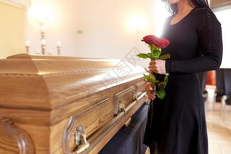 讣告人们哀悼的女人带着红玫瑰棺材教堂的葬礼上葬礼上带着红玫瑰棺材的女人背景
