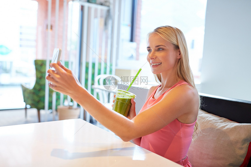 技术,人休闲快乐的女人与智能手机冰沙饮料素食奶昔餐厅自拍智能手机的女人餐馆自拍图片