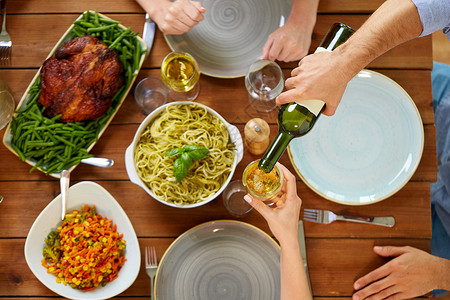 感恩节,饮食休闲群人餐桌上吃晚饭,喝葡萄酒群人吃喝葡萄酒背景图片