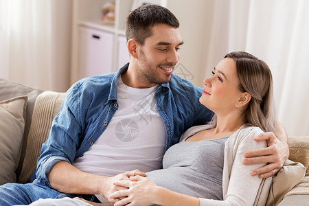 怀孕人们的快乐的男人拥抱孕妇家男人家里拥抱孕妇房间高清图片素材