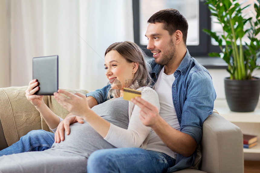 网上购物,怀孕技术快乐的男人他怀孕的妻子家里用平板电脑信用卡男人怀孕的妻子家网上购物图片