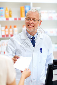 医药,医疗人的高级药剂师药房的顾客那里服用处方药房处方的高级药剂师图片