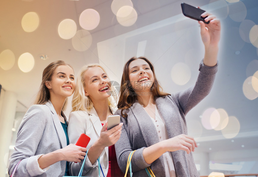 销售,消费主义,技术人的快乐的轻妇女与智能手机购物袋购物中心自拍智能手机购物自拍的女人图片