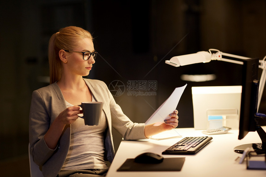 商业,截止日期技术女商人与文件电脑夜间办公室工作喝咖啡带着文件夜间办公室工作的女商人图片