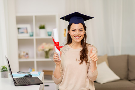 教育毕业人的快乐的女学生家里文凭,竖大拇指家里文凭的学生竖大拇指微笑高清图片素材
