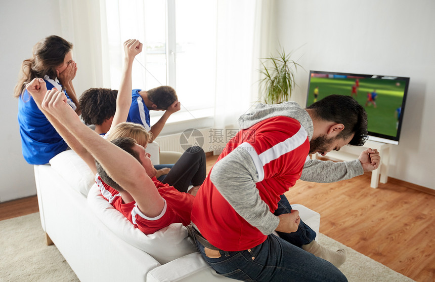体育人娱乐活动快乐的朋友球迷电视上看足球比赛,并家里庆祝胜利足球迷家看电视上的足球比赛图片