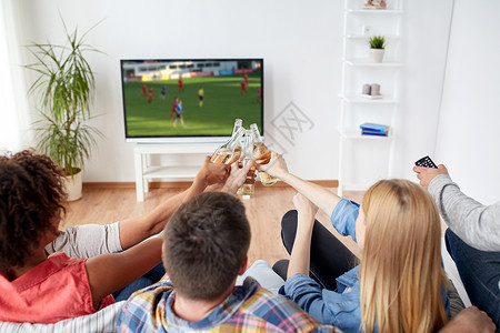 休闲人的快乐的朋友们喝啤酒看足球比赛图片