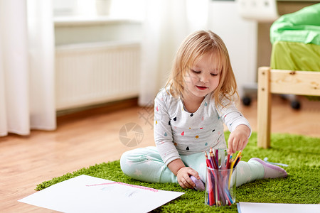 童,活动人的快乐的小女孩用蜡笔家里画画快乐的小女孩家里画画图片