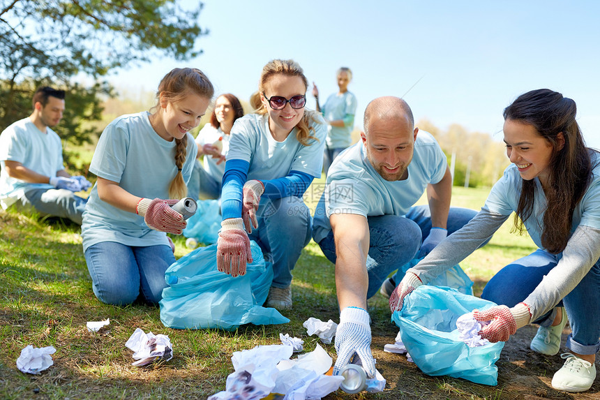 志愿服务慈善人与生态理念公园垃圾袋清洁区的群快乐志愿者志愿者用垃圾袋清洁公园区域图片