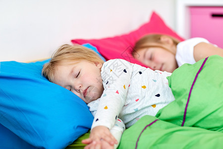 童,睡觉时间家庭快乐的小女孩姐妹睡家里的床上快乐的小女孩睡家里的床上图片