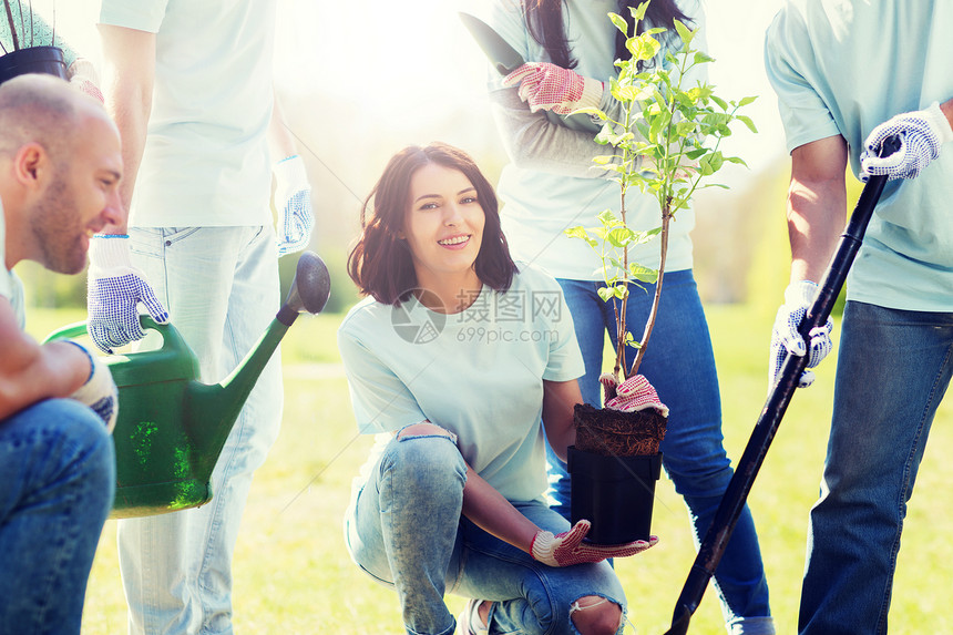 志愿服务慈善人生态理念群快乐的志愿者公园里植树用铲子挖洞群志愿者公园植树图片