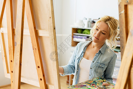 艺术学校,创造力人的妇女与画架调色板绘画工作室艺术学校工作室画画画架的女人教育高清图片素材