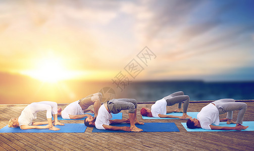 瑜伽图健身,瑜伽健康的生活方式群人海上背景的木墩上桥式户外运动群人户外瑜伽桥姿势背景