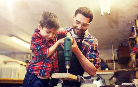 家庭,木工,木工人的父亲小儿子车间用钻孔木板父亲儿子车间工作背景图片