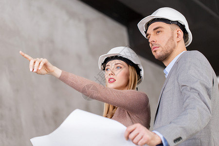 建筑,建筑业务人的建筑师与蓝图头盔指向某物带蓝图的头盔的建筑师图片