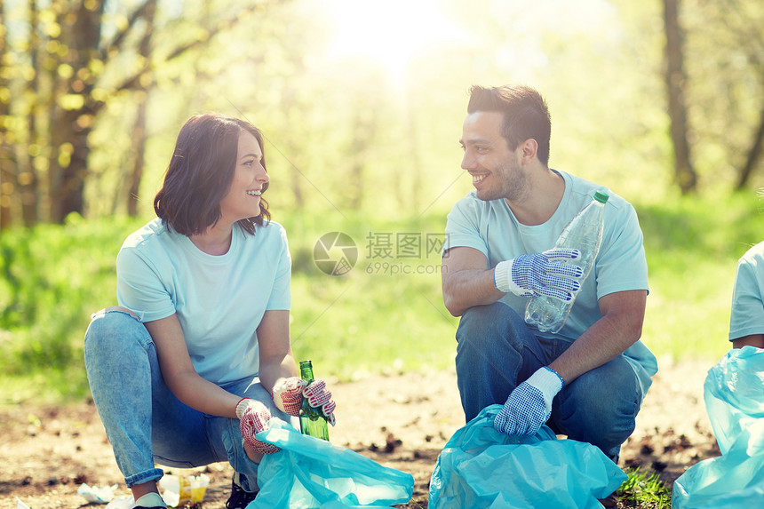 志愿服务慈善人与生态理念公园垃圾袋清洁区的群快乐志愿者志愿者用垃圾袋清洁公园区域图片