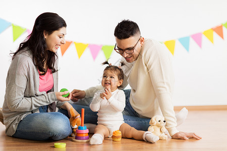带孩子玩的父亲家庭,假期人的快乐的母亲,父亲小女儿生日聚会上玩玩具带着父母玩玩具的女婴带着父母玩玩具的女婴背景