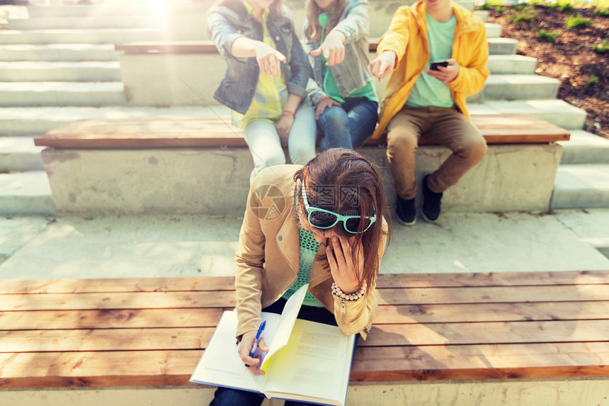 教育,欺凌,高中,社会关系人的快乐的学生女孩与书中的同学遭受嘲弄学生女孩遭受同学嘲笑学生女孩遭受同学嘲笑图片