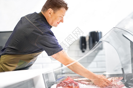 食品销售,小企业人的男卖家与海鲜鱼店冰箱卖海鲜的男鱼店冰箱卖海鲜的男鱼店冰箱背景图片