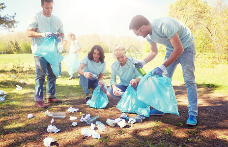 成人袋子志愿服务慈善人与生态理念公园垃圾袋清洁区的群快乐志愿者志愿者用垃圾袋清洁公园区域志愿者用垃圾袋清洁公园区域背景