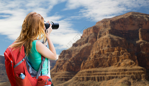 旅行,旅游摄影快乐的轻妇女背包相机拍摄大峡谷公园的背景大峡谷带背包照相机的女人大峡谷带背包照相夏天高清图片素材