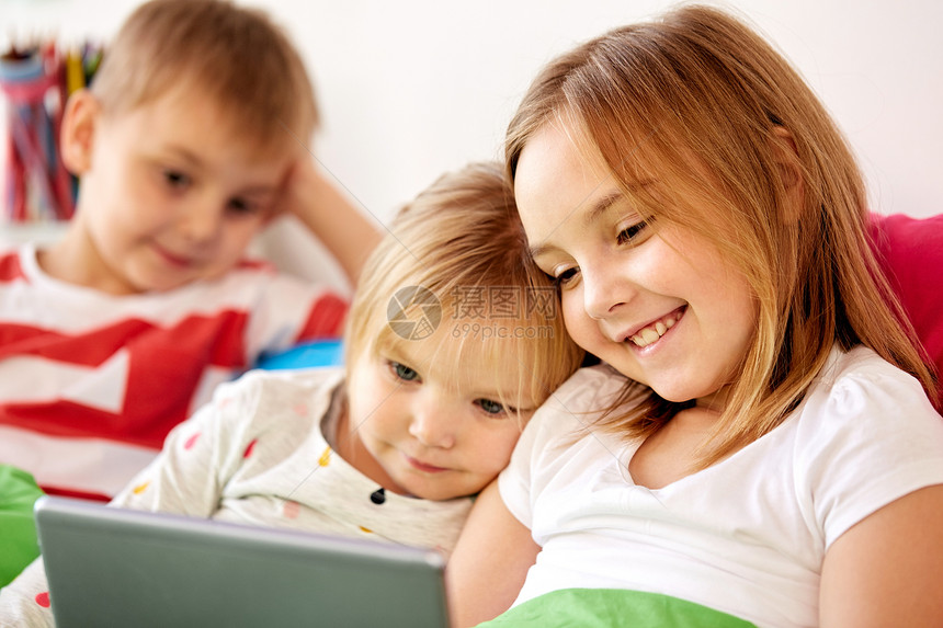 童,技术家庭快乐的孩子与平板电脑电脑床上家快乐的小孩子家里的床上用平板电脑快乐的小孩子家里的床上用平板图片