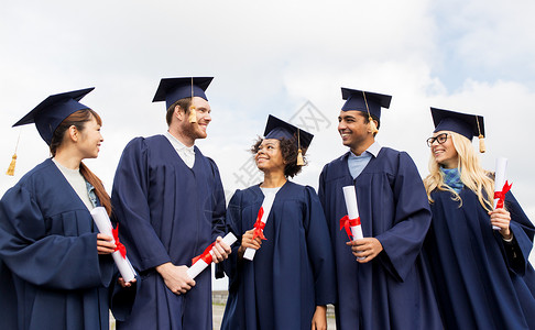 图文快印教育毕业人的群快乐的国际学生穿着迫击炮板学士学位礼服与文凭文凭的迫击炮板上快乐的学生文凭的迫击炮板上快背景