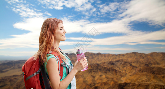冒险,旅行,旅游,徒步旅行人们的微笑的轻女人带着背包瓶水大峡谷公园的山丘背景上带着背包山上微笑的女人背景图片