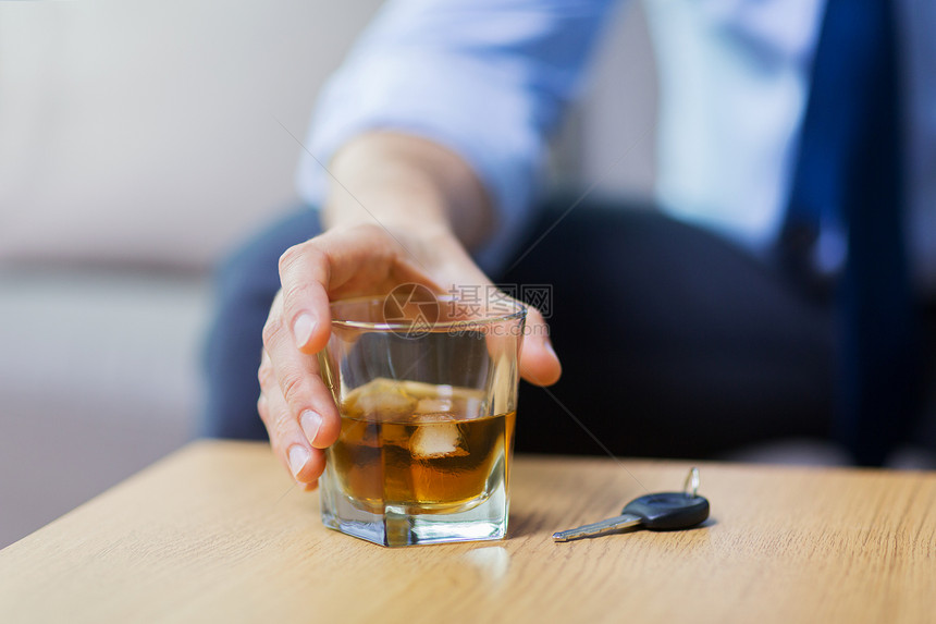 酗酒,醉酒驾驶人的男司机的手与威士忌璃汽车钥匙桌子上把酒精汽车钥匙放桌子上把酒精汽车钥匙放桌图片