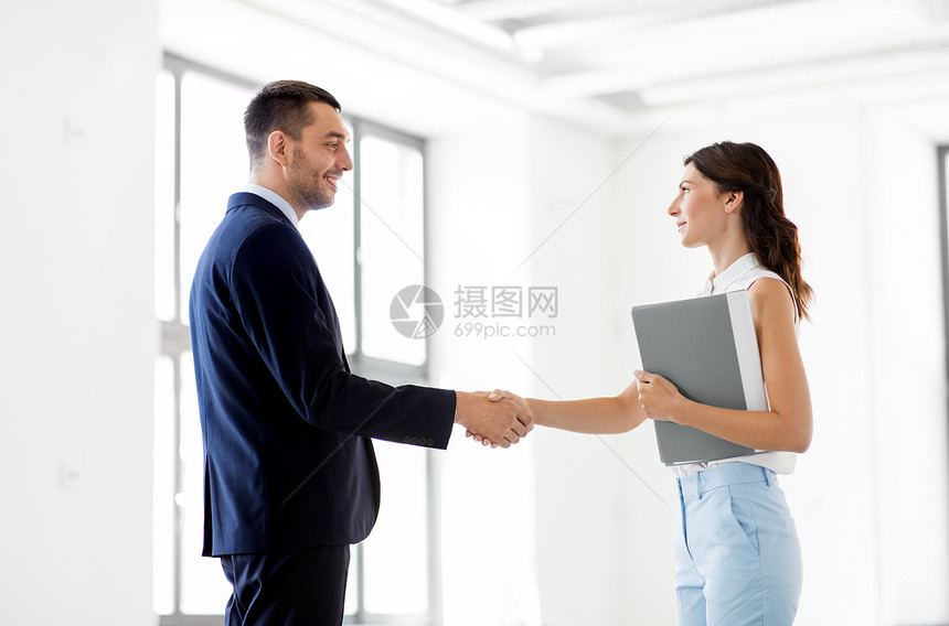 微笑的女商人在办公室握手图片