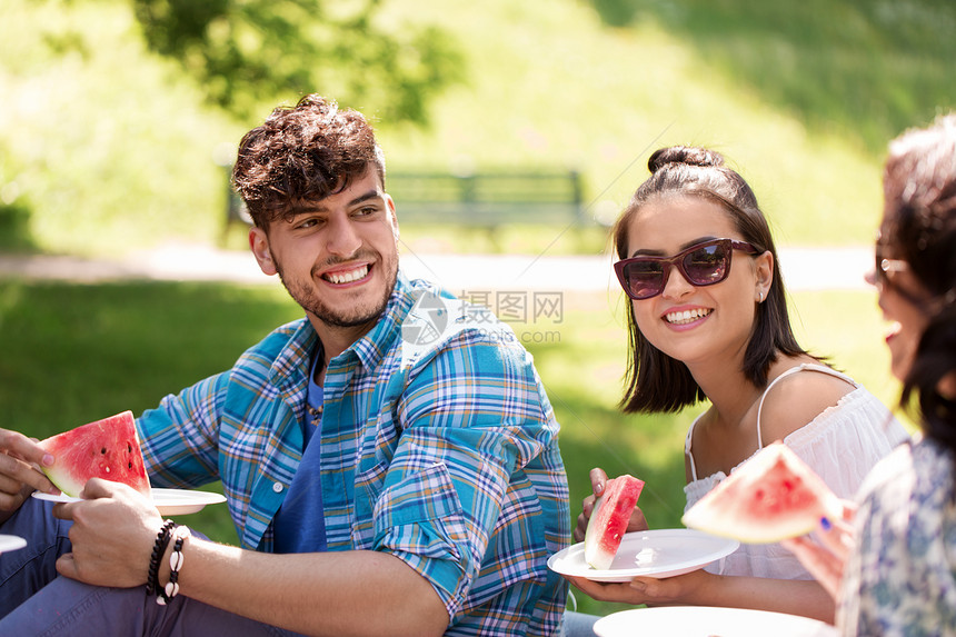 友谊休闲夏天的群快乐的朋友公园野餐时吃西瓜快乐的朋友夏天野餐时吃西瓜快乐的朋友夏天野餐时吃西瓜图片