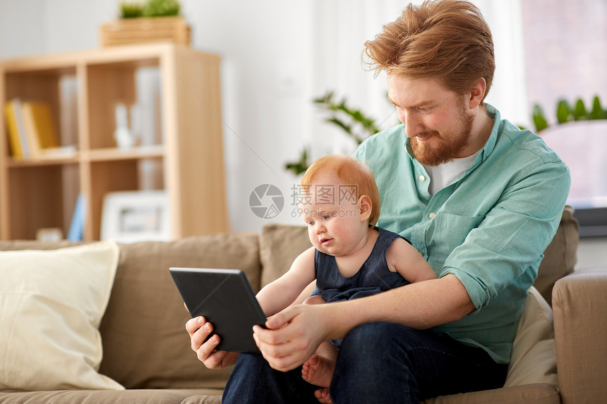 家庭,父亲技术快乐的红头发父亲小女儿与平板电脑电脑家里父亲婴儿女儿家用平板电脑父亲婴儿女儿家用平板电图片