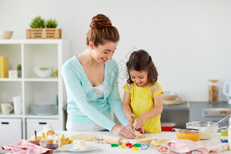 家庭,烹饪人们的快乐的母亲小女儿用模具家里厨房用饼干快乐的母亲女儿家饼干背景图片