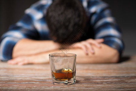 酒精男酒精与杯威士忌躺桌子上晚上睡觉晚上桌子上喝了杯酒的醉汉背景图片