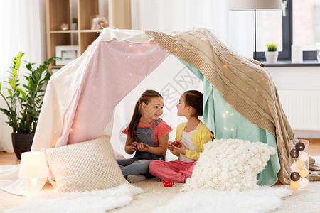 童潮湿的快乐的小女孩玩茶玩具陶器孩子们的帐篷家里小女孩家孩子们的帐篷里玩茶话会背景图片