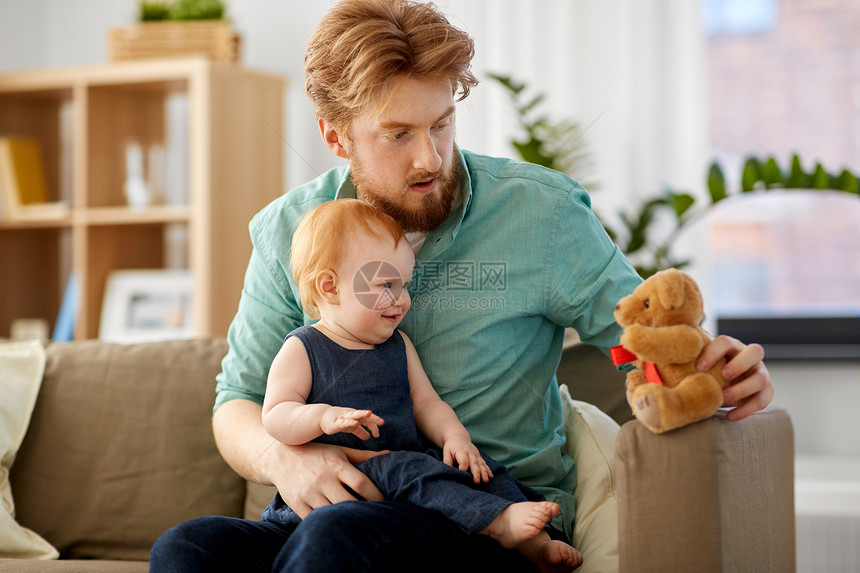 家庭,父亲人的快乐的红头发父亲小宝贝女儿家里玩泰迪熊爸爸宝贝女儿家带着泰迪熊图片