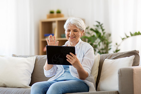 技术,人沟通的快乐的老年女子与平板电脑电脑视频聊天家高级女平板电脑上进行视频聊天坐高清图片素材