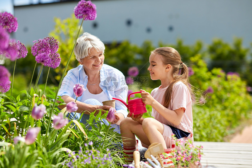 园艺,家庭人的快乐的祖母孙女夏季花园种花祖母女孩花园里种花图片
