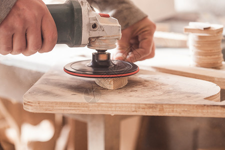 工人抛光木桌,木匠用电砂机打磨木材用于木材的砂光机背景图片