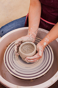 试图陶工的车轮上用白色粘土制作陶器的女孩的肖像儿童陶瓷工艺品图片