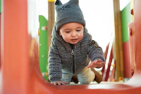 蹒跚学步的孩子玩得开心小男孩蹒跚学步的公园里玩得很开心图片