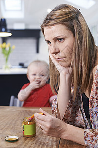 压力很大的母亲试图喂养挑剔的婴儿图片
